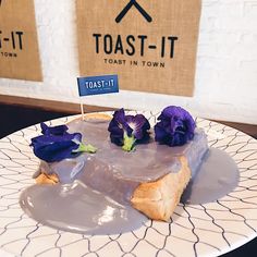 a piece of cake sitting on top of a plate covered in frosting and purple flowers