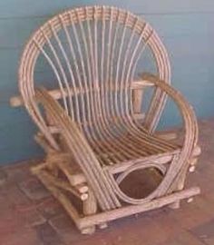 a wicker chair sitting on top of a brick floor next to a blue wall