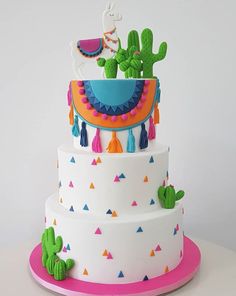 a three tiered cake decorated with cactuses and tassels