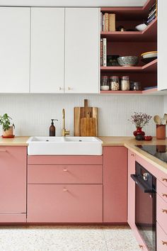 a kitchen with pink cabinets and white cupboards is pictured in this image from the front view