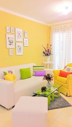 a living room with yellow walls and white furniture