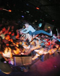 a man on a skateboard doing tricks in front of an audience at a concert