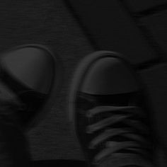 a person's feet in black and white sneakers