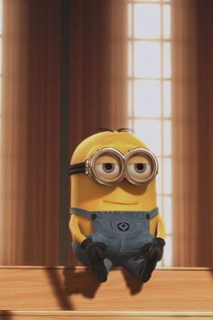 a minion sitting on top of a wooden table