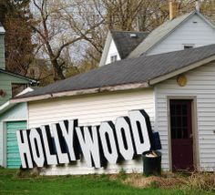 an old building with the word hollywood painted on it's side in front of some houses