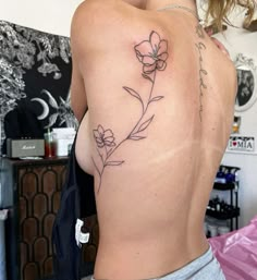 a woman with a flower tattoo on her back