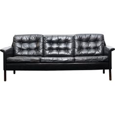 a black leather couch with wooden legs