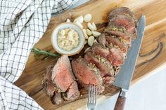 sliced meat on a cutting board with knife and fork