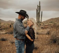 a man and woman standing next to each other in the desert