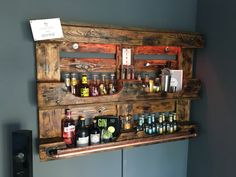 a wooden shelf filled with lots of bottles and glasses on top of a wall next to a speaker