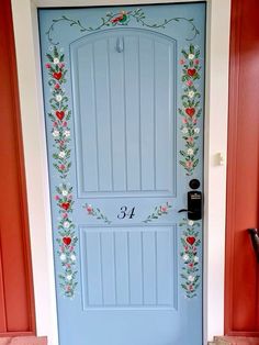 a blue front door decorated with flowers and hearts