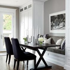 a dining room table with black chairs and a bench