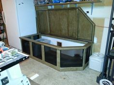 an unfinished bathtub in the middle of a room with shelves and other items on the floor