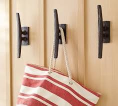 a red and white striped bag hanging on a door handle next to a pair of hooks