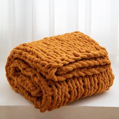 a stack of orange towels sitting on top of a white counter