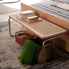 a table that has some books on it next to a basket with a green blanket