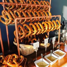 several different types of pretzels and dips are on display at a buffet