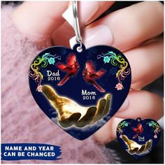 a heart shaped keychain with two birds on it and the words dad, mom, and child