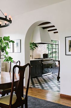 a dining room table with chairs and a potted plant in the middle of it