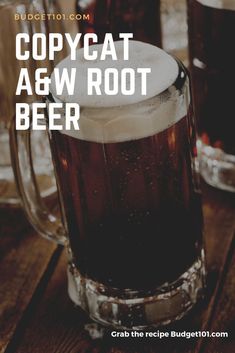 a beer mug sitting on top of a wooden table next to two glasses filled with liquid