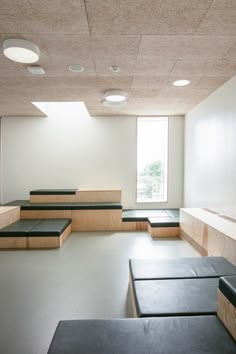 an empty room with benches and windows