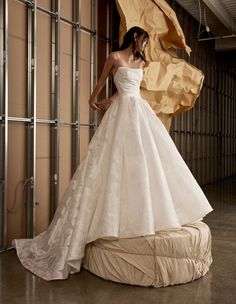 a woman in a wedding dress standing on a mattress