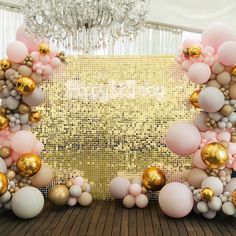 a large balloon arch with gold and pink balloons