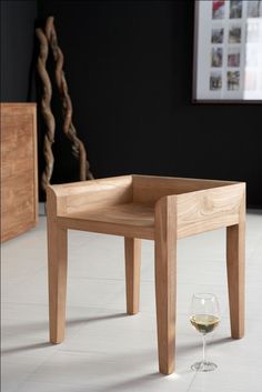 a small wooden table with a glass of wine on the floor