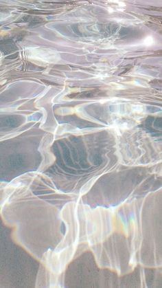 the water is crystal clear and there are ripples on the surface that make it appear to be floating