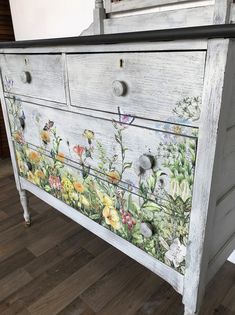 an old dresser painted with flowers and butterflies on the drawers is shown in this image