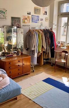 a bedroom filled with lots of clothes and furniture