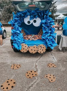 the back end of a car decorated with blue paper and cookie cookies on it's trunk