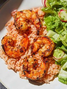 shrimp, rice and salad on a white plate