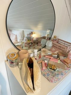 a mirror sitting on top of a white counter next to a bag and other items