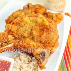 fried chicken with rice and sauce on a plate