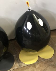 two black and yellow vases sitting next to each other on the floor in front of a wall