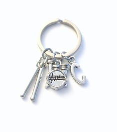 a metal keychain with an umbrella and keys attached to it, on a white background