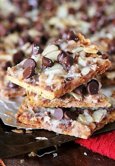 someone is picking up some chocolate chip cookie bars from the tray on top of the table