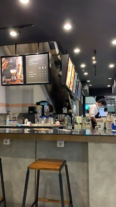 two stools in front of a counter with menus on the wall behind it