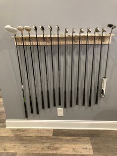 there are many golf clubs hanging on the wall