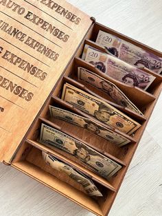 a wooden box filled with money sitting on top of a table