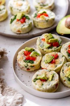 small appetizers on plates with avocado slices and other food items in the background