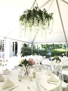 the tables are set with white linens and place settings for an outdoor wedding reception