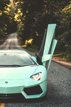 a blue sports car parked on the side of a road