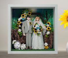 a wedding cake topper with sunflowers and a bride and groom