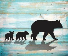 a bear and two cubs are silhouetted against a painted wood background