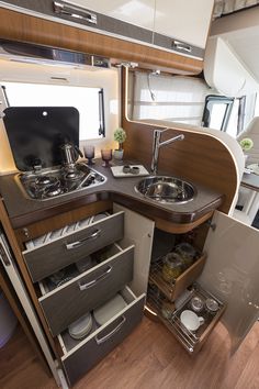 an rv kitchen with sink, stove and cabinets