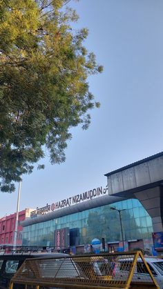 the entrance to an airport with cars parked in front and trees growing out of it