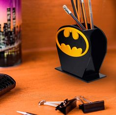 a batman pen holder is sitting on a desk