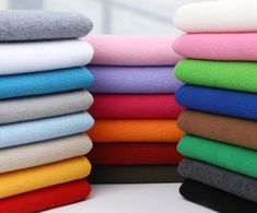 a stack of different colored towels sitting next to each other on top of a table